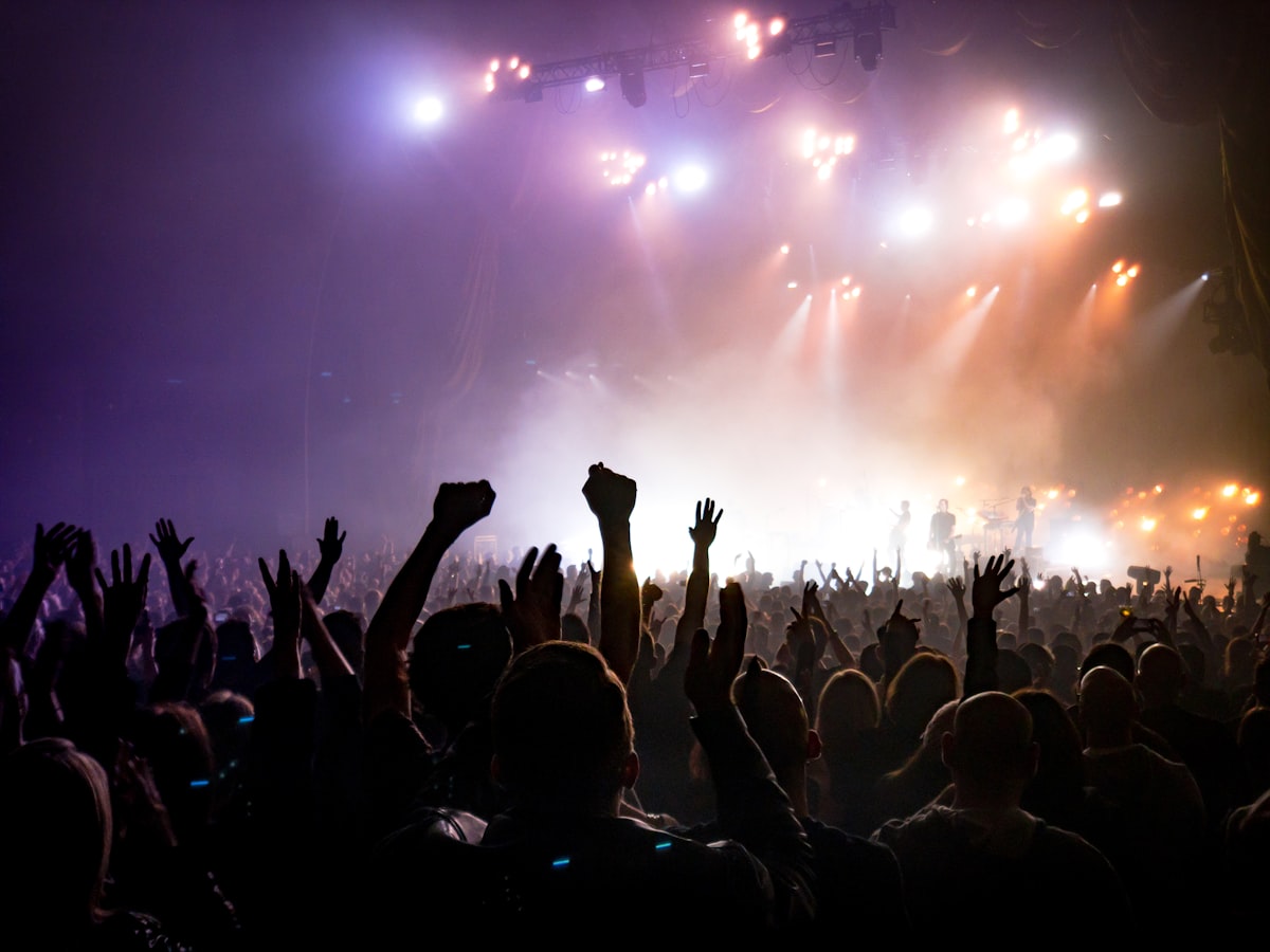 Promotor de eventos gestionando un concierto en directo con su equipo entre bastidores